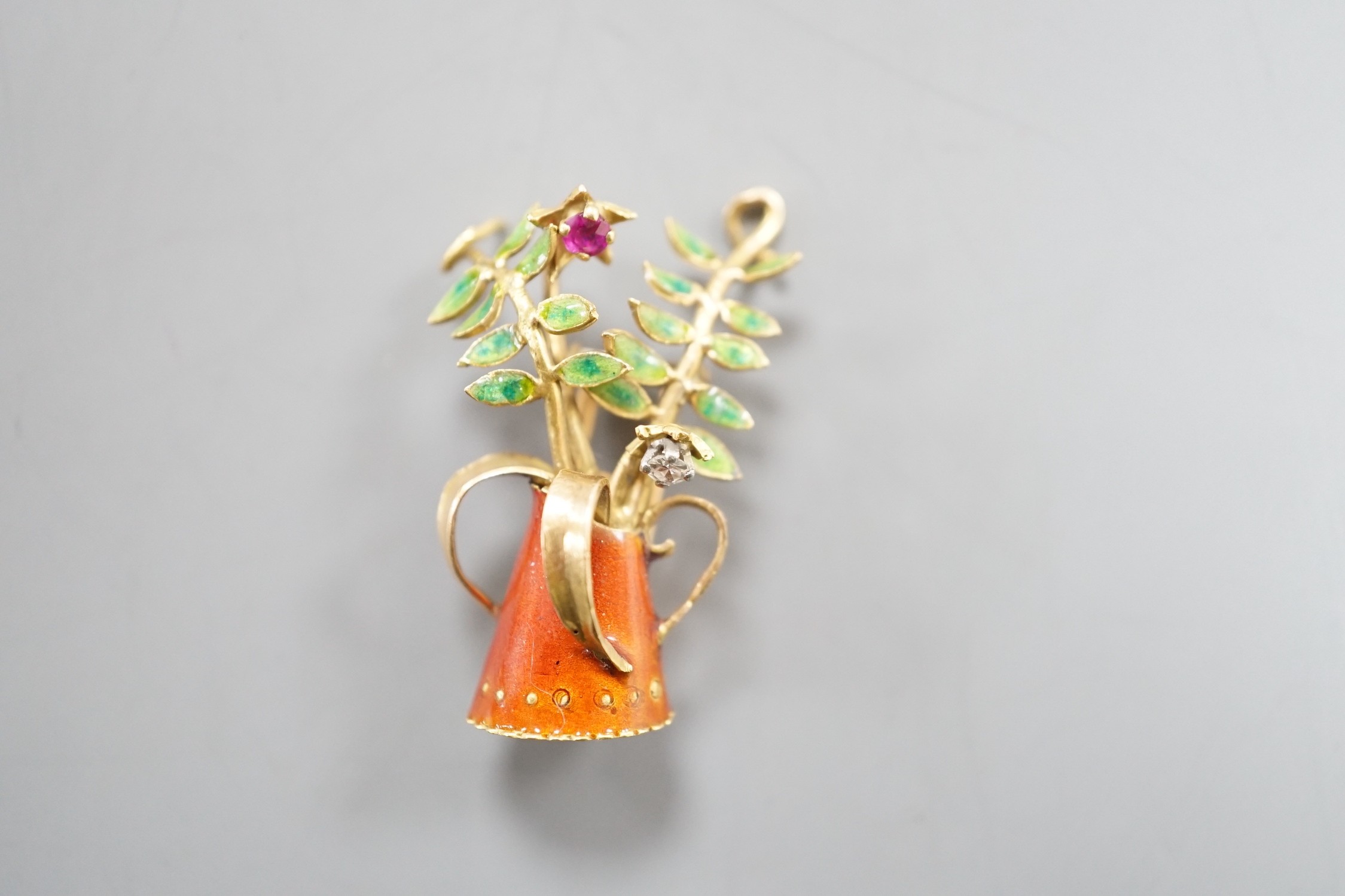 A French yellow metal (18ct poincon mark), two colour enamel, ruby and diamond set novelty brooch, modelled as a tyg with foliate stems, signed Marcel Pac, Paris, 29mm, gross weight 5.8 grams.